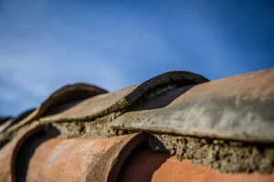Cómo Evitar Filtraciones y Mantener tu Hogar Protegido 1 Top Tejados Burgos Vista en primer plano de una teja de techo con huecos visibles, destacando el potencial de filtraciones de agua